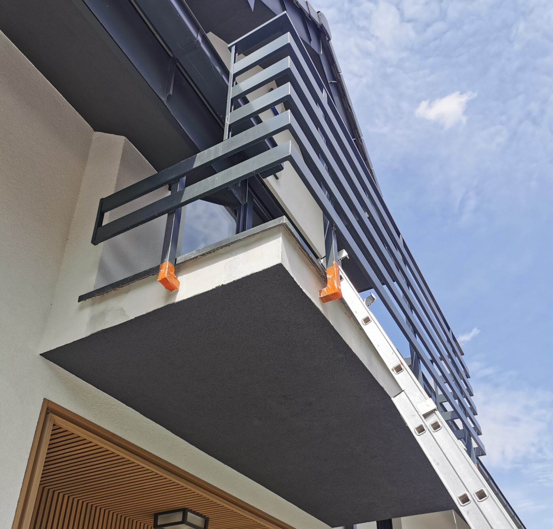 Detal wykończonego balkonu z ciemną balustradą