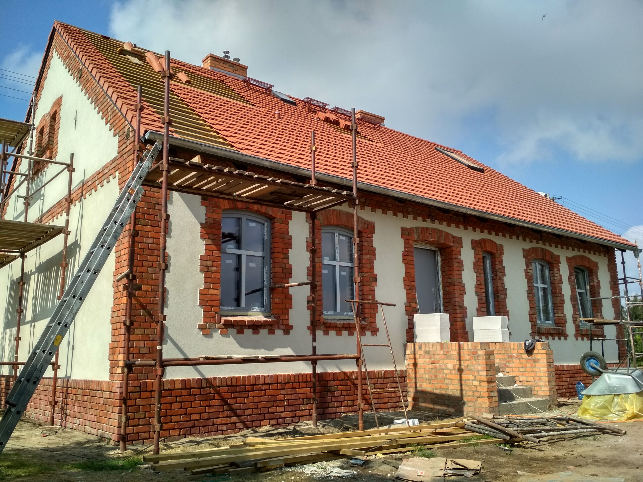 Ukończony dach z czerwonej dachówki na ceglanym budynku dawnej poczty w Kórniku