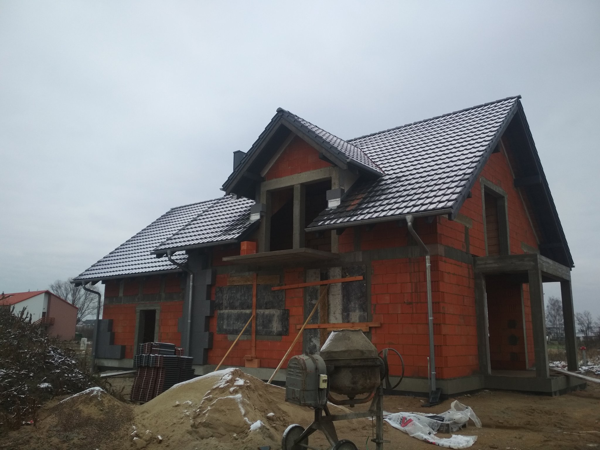 Pokryty dach z lukarną nad wejściem, widok z boku