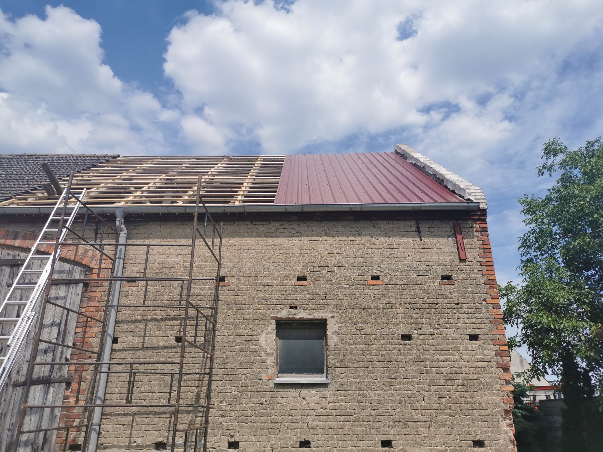 Wymiana pokrycia — część dachu odkryta, część pokryta blachą